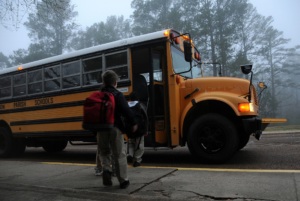 school kids getting on bus